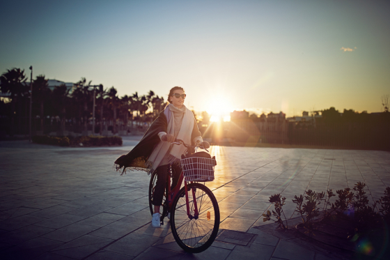 Woman wearing polarised lenses on a bicycle with a sunset in the background